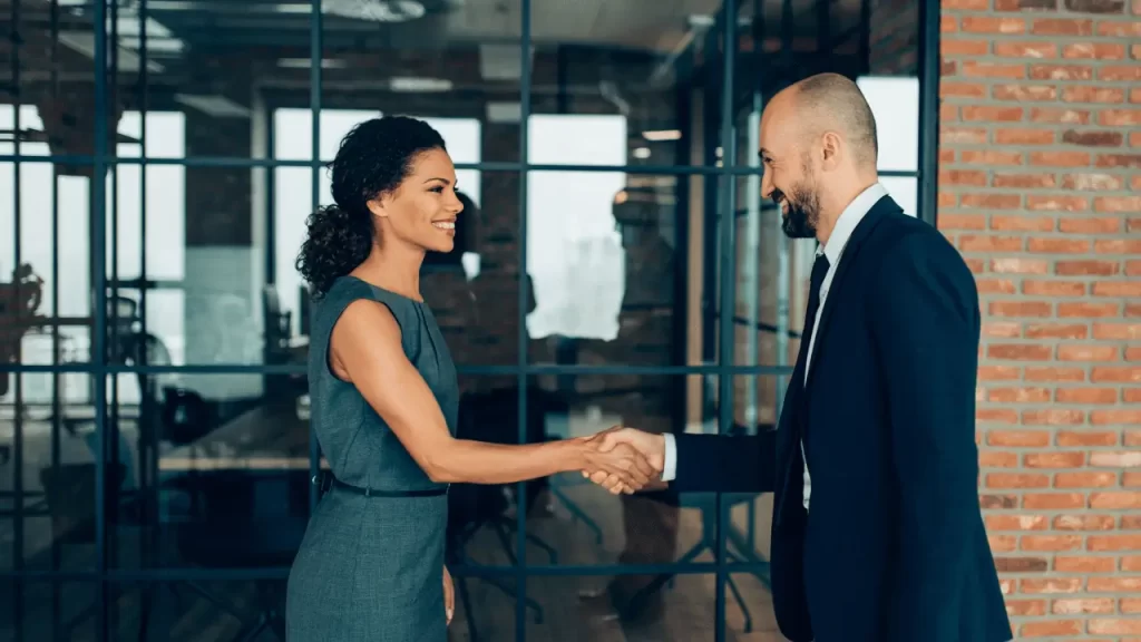 Man and woman on business environment compliment each other - thank you for your business lsi - Language Systems International Man and woman on business environment compliment each other