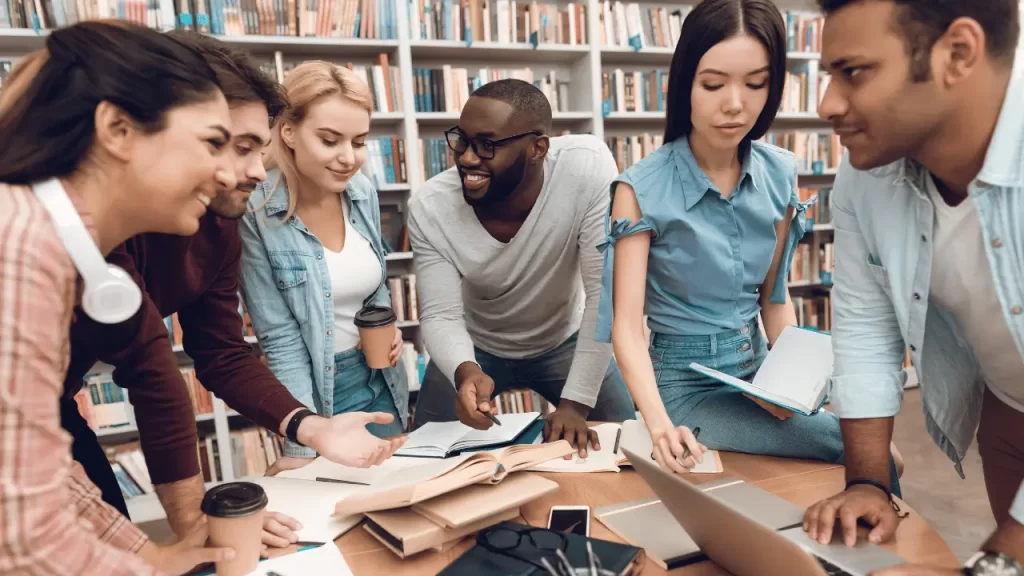 International students smiling to each other in a library