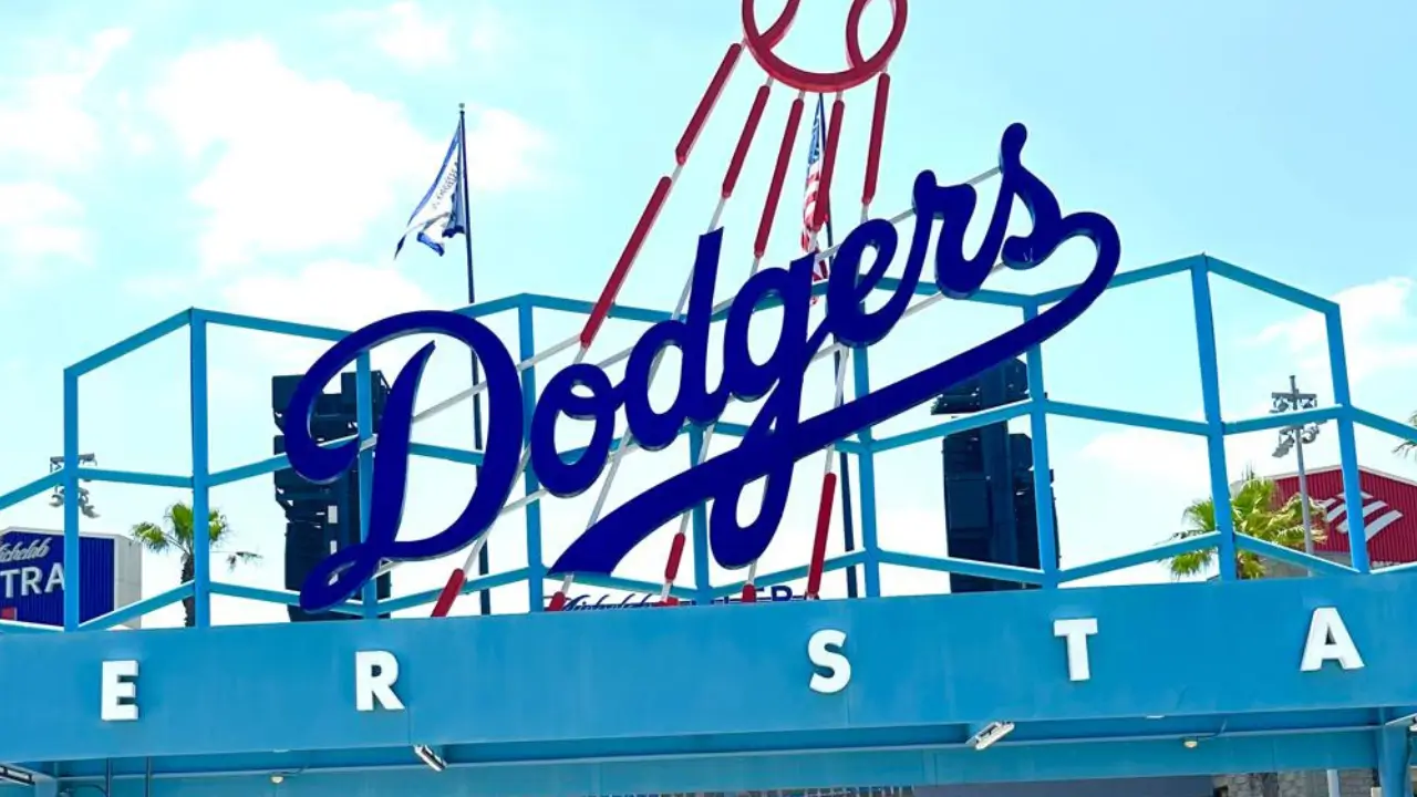 The photo shows a sign reading "Dodgers" on the door of the Dogers baseball team's stadium.
