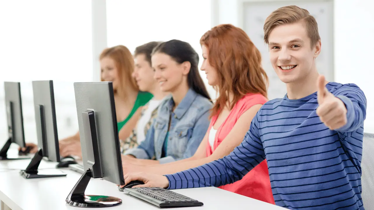 Student smiling in front of a computer